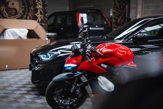 Ducati vermelha e BMW M2 em oficina